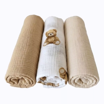 Zestaw trzech zwiniętych w rulon otulaczy z pofalowanego muślinu bawełnianego Double Gauze wyeksponowanych na białym tle. W środku znajduje się śmietankowa pieluszka z nadrukiem uroczego, siedzącego brązowego misia z kolekcji Bajkowe Misie. Po bokach ułoż