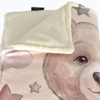 Zbliżenie na kremowy polar, obszycie i fragment nadruku misia Lilu na kocyku Minky.