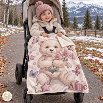 Dziecko w wózku przykryte kocykiem Minky Miś Lilu z orchideą podczas zimowego spaceru.