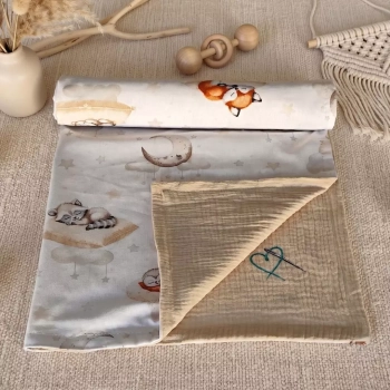 Dwustronny kocyk niemowlęcy w rolce (bawełna/muślin). Wzór Leśne Poduszkowe Sny, beżowy spód z logo i tło boho.