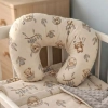 Aranżacja łóżeczka niemowlęcego z poduszką do karmienia i pościelą w misie w stylu boho.