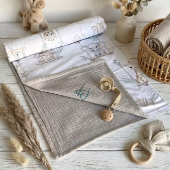 Dwustronny kocyk niemowlęcy (bawełna/muślin) w aranżacji boho. Widoczny wzór Kołysanka z Safari z akwarelowymi zwierzątk