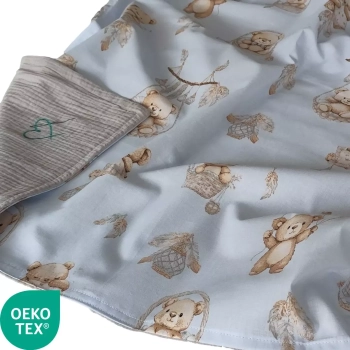Zbliżenie na bawełniano-muślinowy kocyk dla chłopca we wzór Misie Boho Blue z jasnoszarym spodem. Widoczne logo certyfikatu OEKO-TEX.
