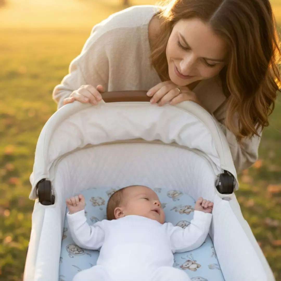 Mama poprawiająca kocyk dziecku w wózku na spacerze prześcieradło Misie Boho