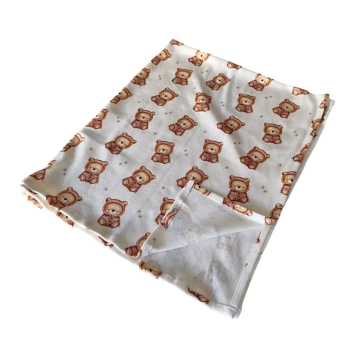 Packshot na białym tle: luźno złożony letni kocyk niemowlęcy z bawełny ażurowej (pointelle). Dolny róg materiału jest lekko wywinięty, pokazując lewą stronę, staranne obszycie oraz jednowarstwową, przewiewną strukturę kocyka bez ocieplenia. Na wierzchniej
