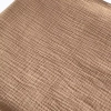 Detaliczne zbliżenie na naturalną, pofalowaną fakturę muślinu bawełnianego w eleganckim odcieniu ciemnego beżu (Coffee), ukazujące charakterystyczny, oddychający splot tkaniny.