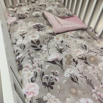 Zbliżenie na bawełnianą tkaninę pościeli niemowlęcej. Botaniczny wzór Retro Bloom z akwarelowymi piwoniami w kolorze brudnego różu i drobnymi polnymi kwiatami na szarobeżowym tle (taupe).
