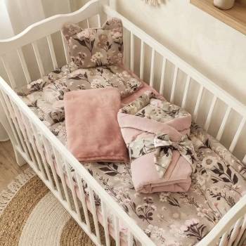 Botaniczna wyprawka dla dziewczynki Retro Bloom. W białym łóżeczku leży poduszka miś, płaska poduszka, złożona kołderka,